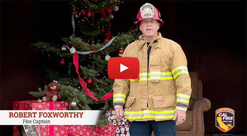 Fire Captain Robert Foxworthy speaking in front of a Christmas background